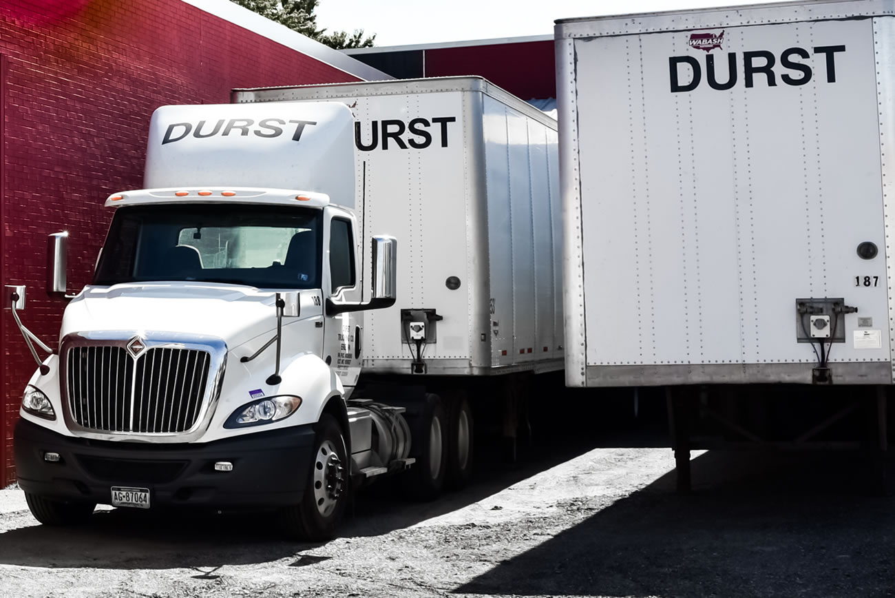 two durst delivery trucks side by side delivering goods